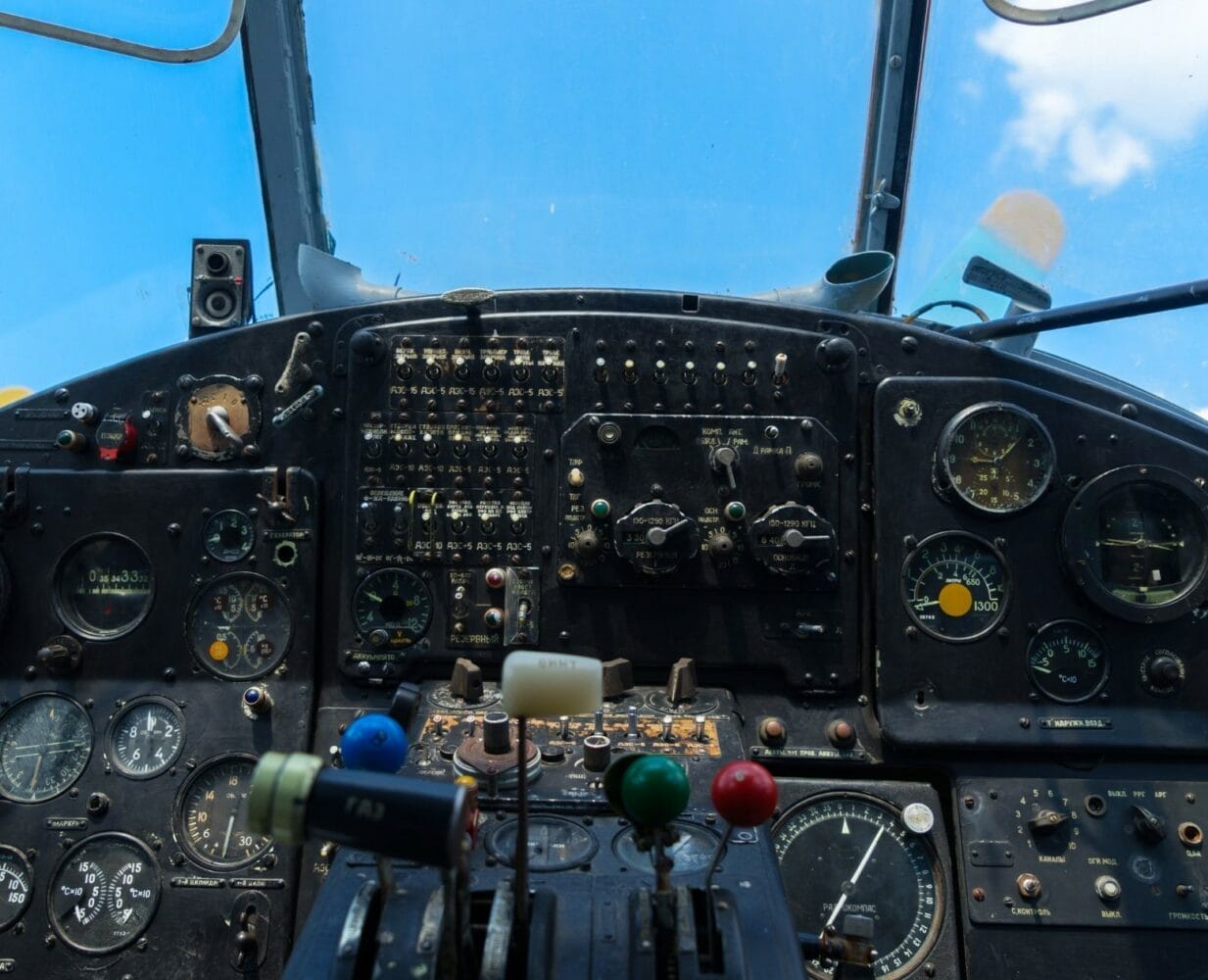 Vintage airplane cockpit with analog gauges, levers, and control panels