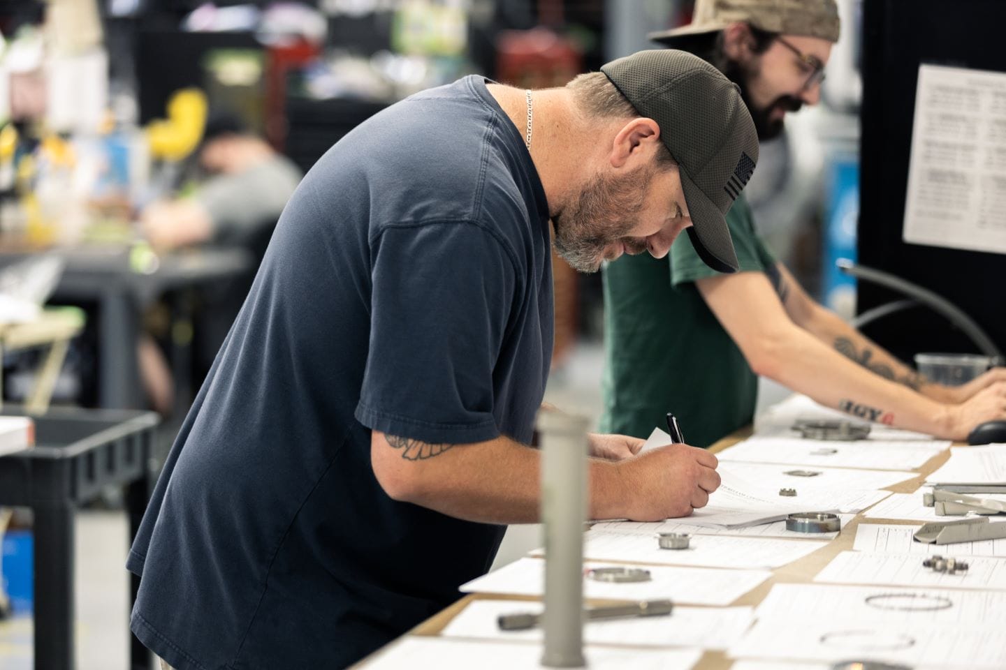 Technician writing notes while inspecting aircraft components on a workbench