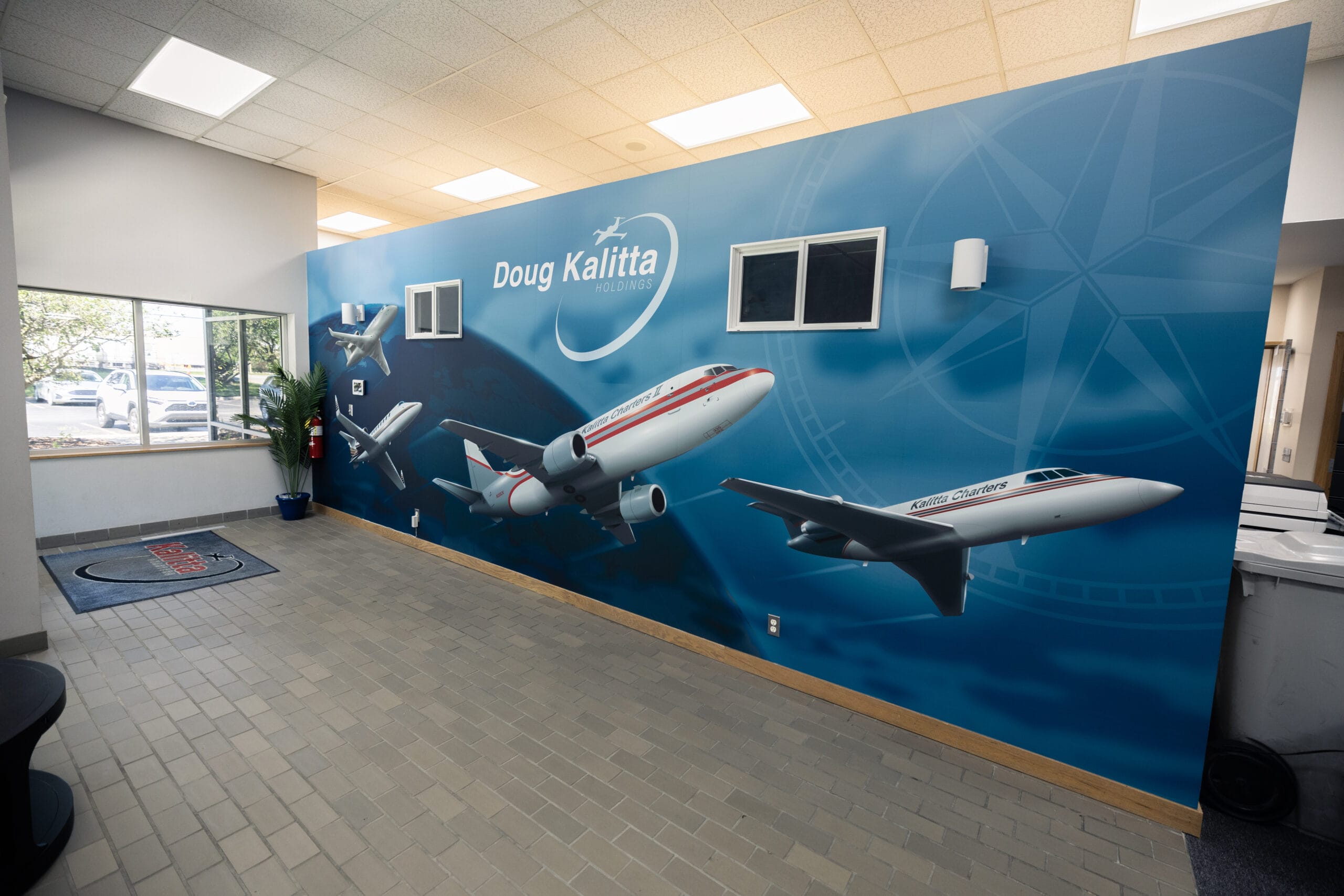 Office lobby with a Doug Kalitta Holdings wall mural featuring airplanes